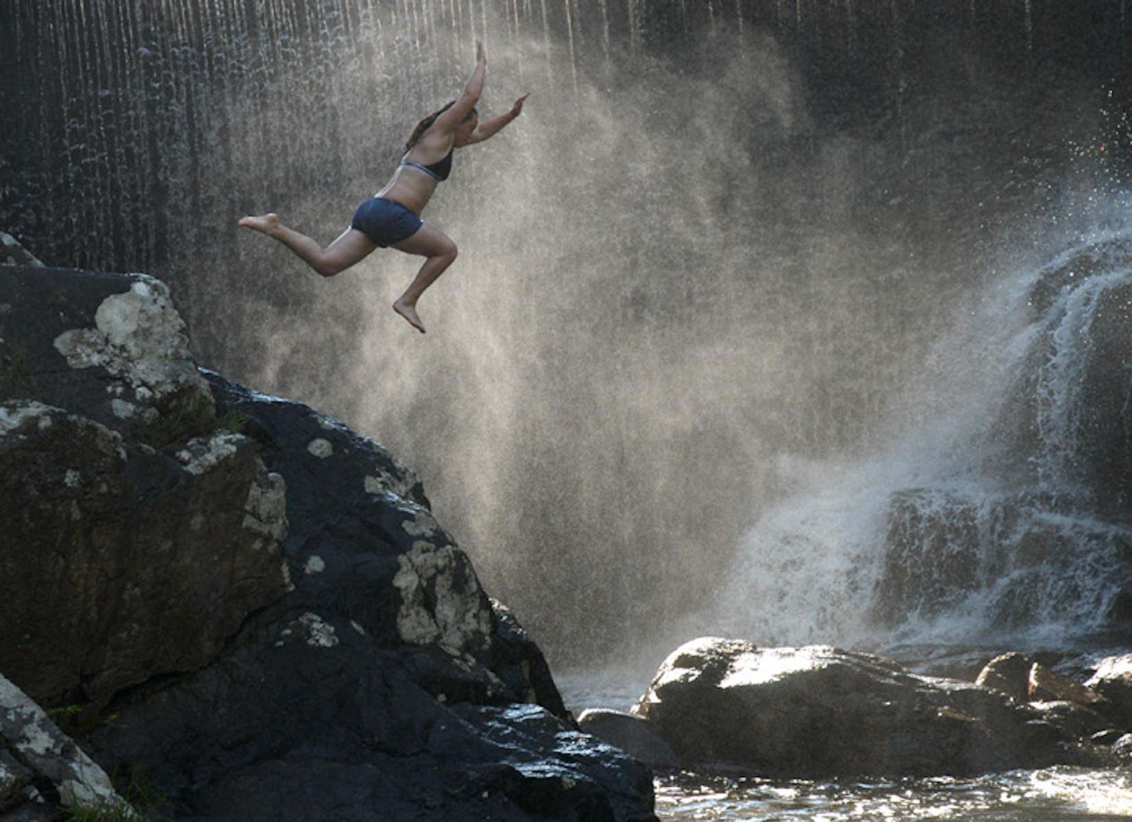 Ashley Jones z West Springfield skacze ze skał na rzece Mill.